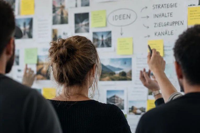 Team arbeitet an einem Moodboard mit Ideen und Sticky Notes