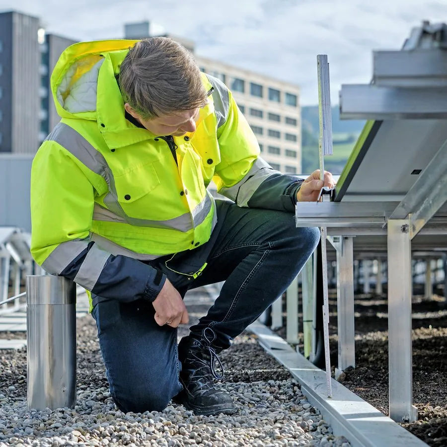 Mitarbeiter vermisst eine Solarpanel-Installation auf einem Dach